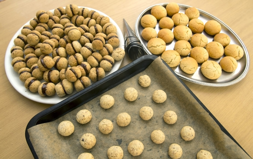 Baci di dama cookies on cooking sheet.