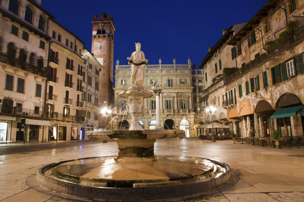 Piazza Erbe at dusk with highlighting the statue of the Madonna. A UNESCO site. 
