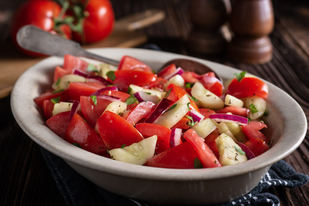 cucumber and tomato salad on white dish. 