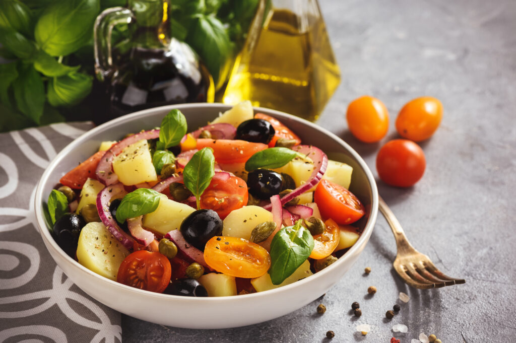 Pantesca salad is a warm summer salad with potatoes, olives, tomatoes, capers and basil. 