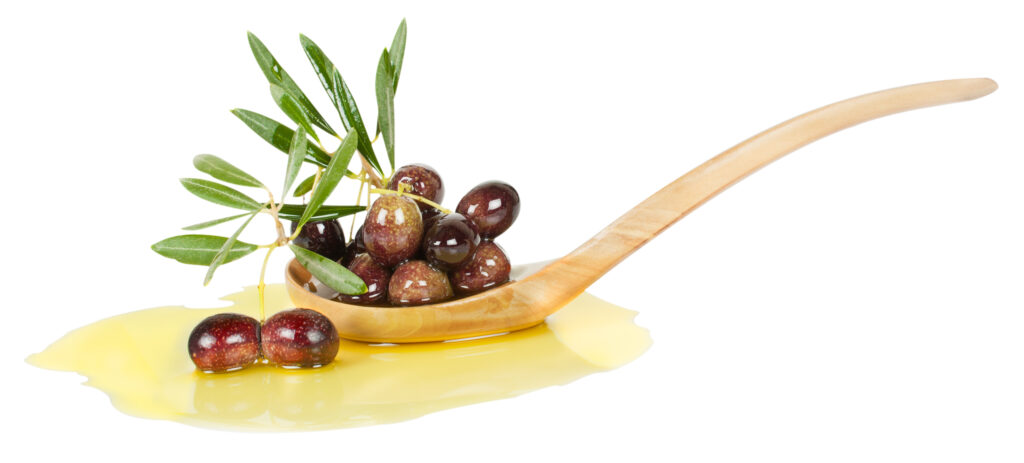 Spilled olive oil, with olives on wooden spoon. 