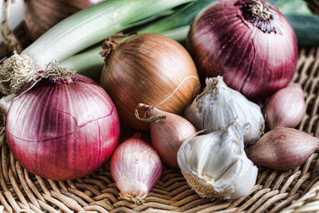 onions, garlic and shallots in a basket. 