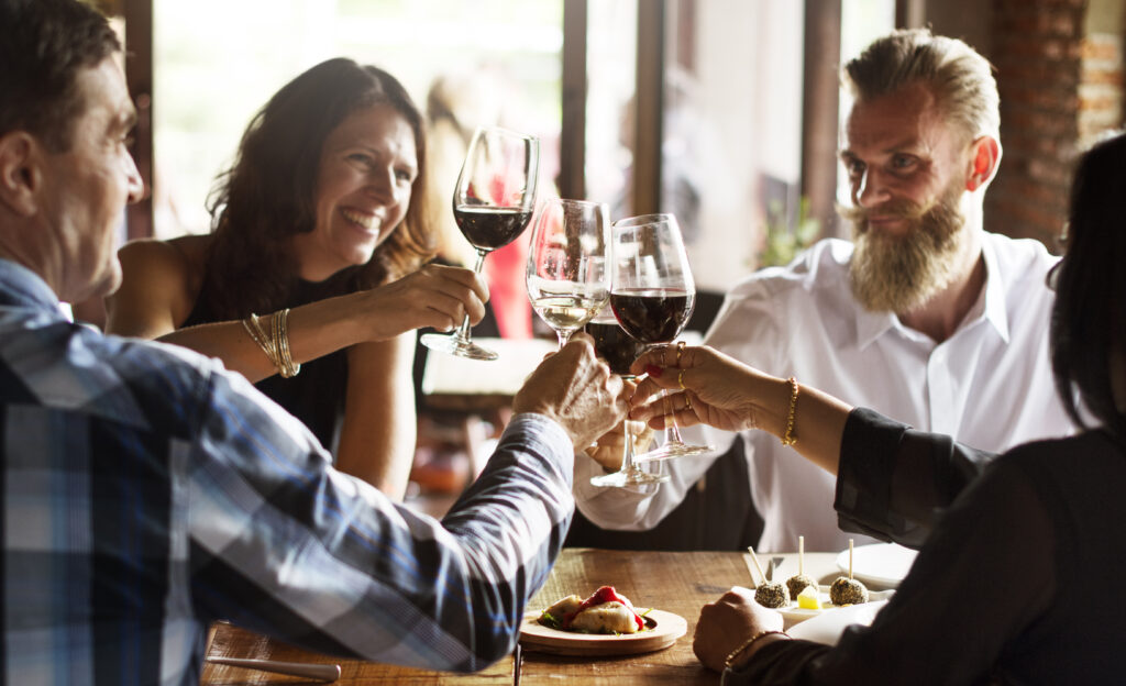 Friends toasting over wine at a classy restaurant. 