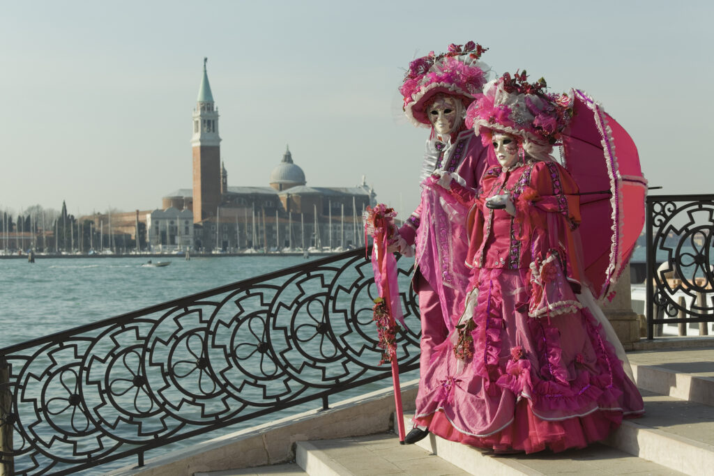 Venetian carnival participants on a bridge. 