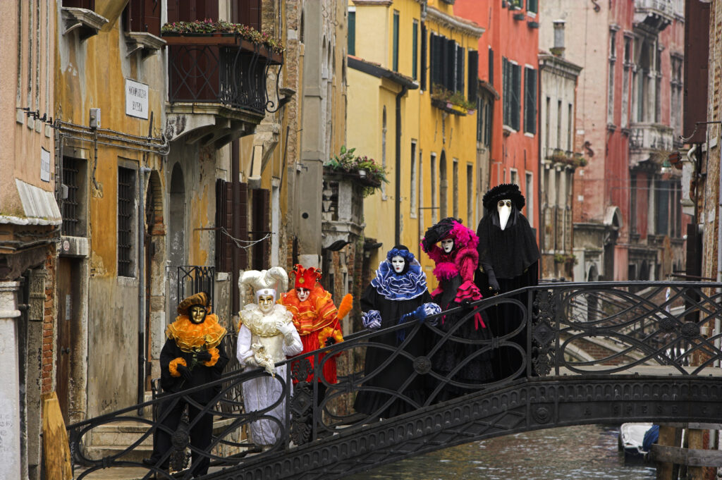 Venetian carnival participants on a bridge. 